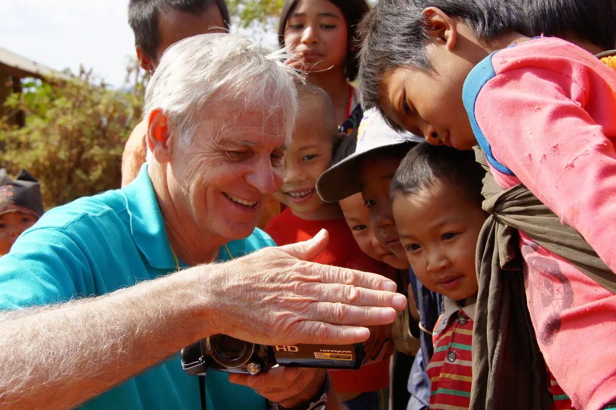 Robert H. Lieberman showing camera footage to a group of children while filming on location